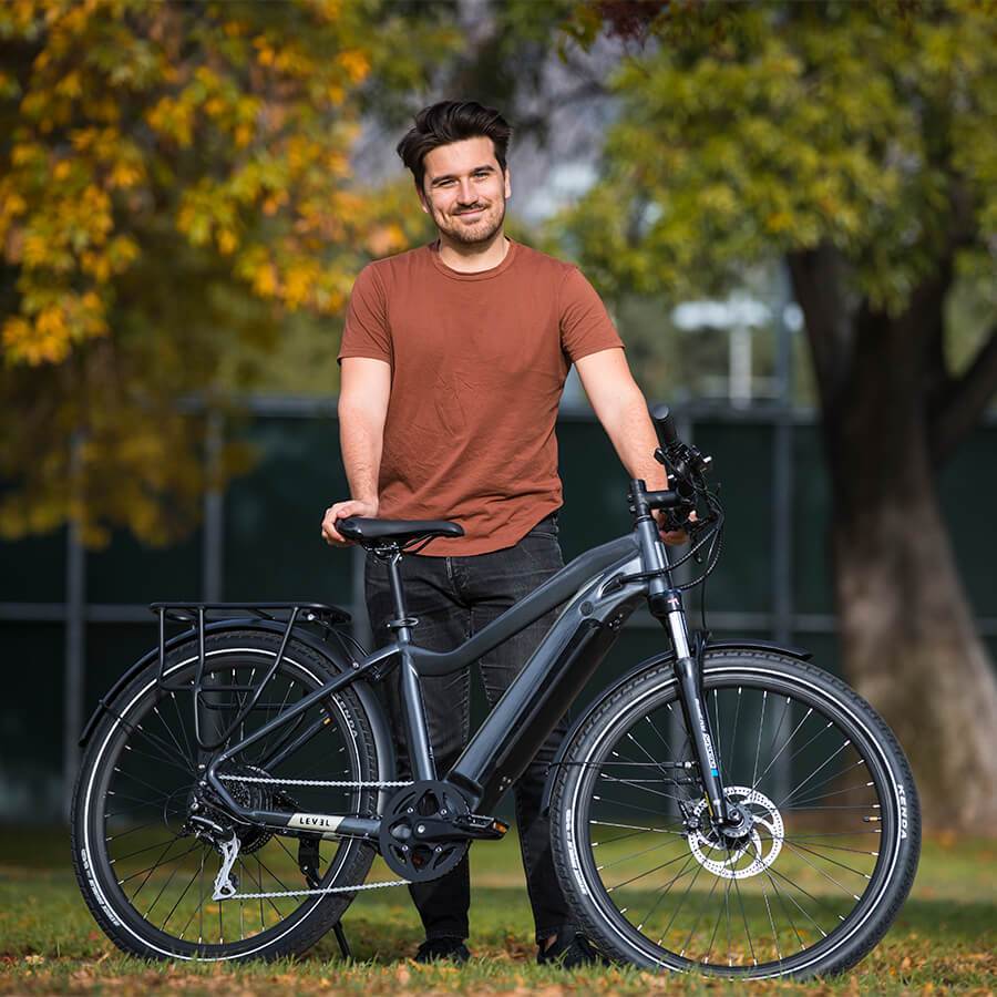 smiling man stands with bicycle