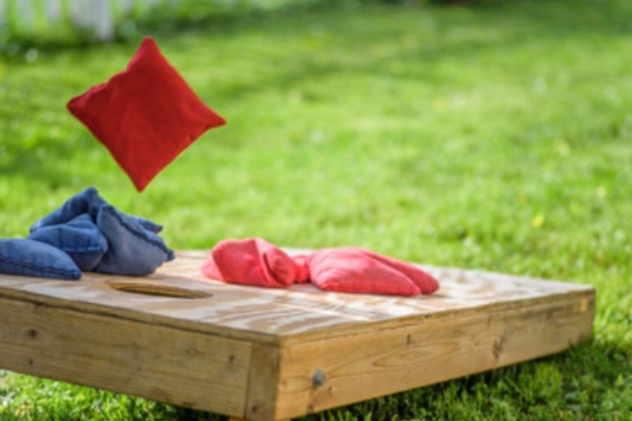 bean bag being thrown in game of corn hole