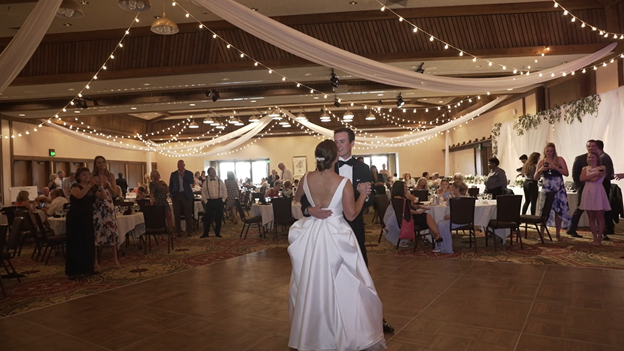 bride and groom dance their first dance while guests surround them