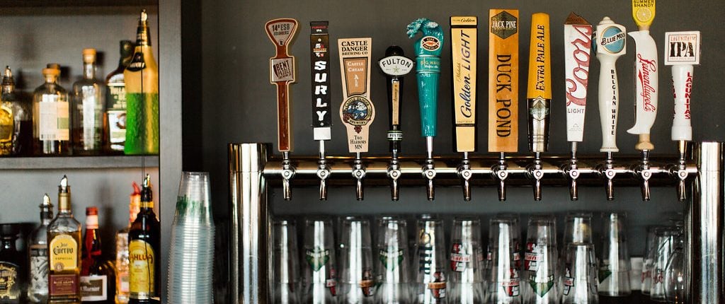 row of beer taps behind a bar