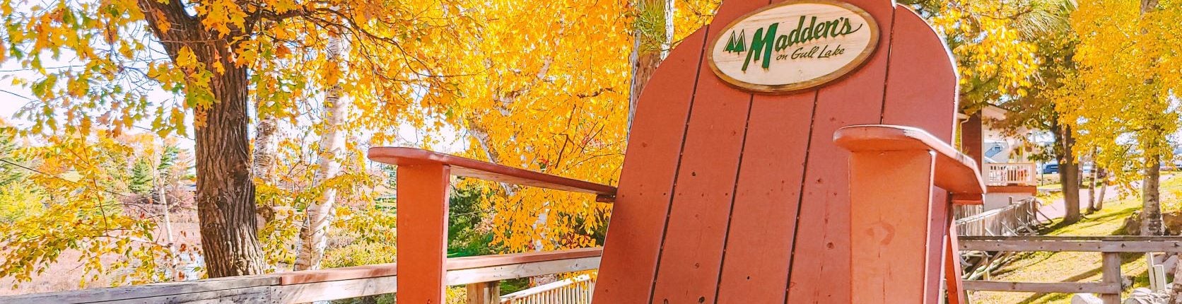 oversized Adirondack chair with autumn trees