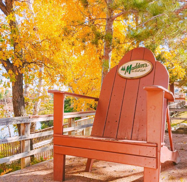 oversized Adirondack chair with autumn trees
