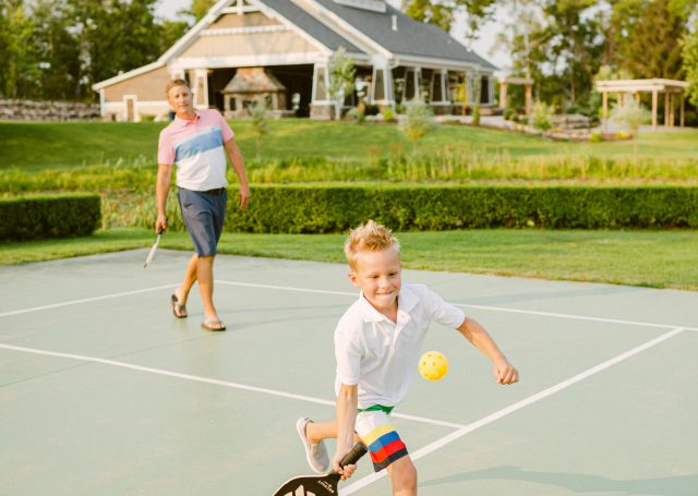 adult and child play tennis