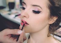 aesthetician applying lipstick on client